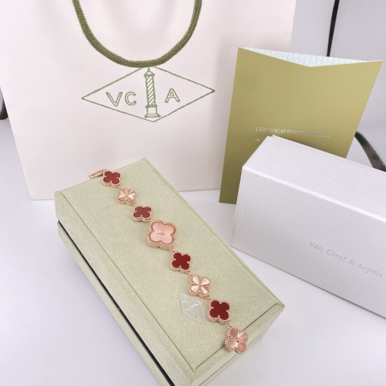 Van Cleef & Arpels watch with a rose gold dial featuring red mother-of-pearl clover motifs.